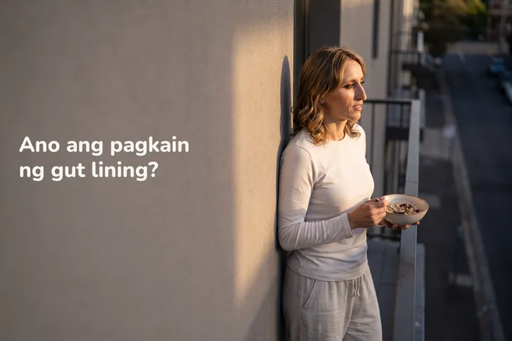 Ano ang pagkain ng gut lining? — isang babaeng bentehin ang kumakain ng oats sa balkonahe sa huling sikat ng araw