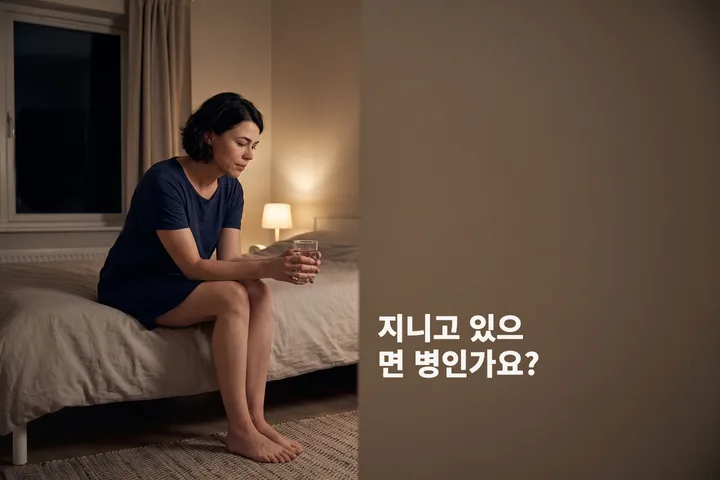 지니고 있으면 병인가요? — 한 여자가 밤에 침대 가장자리에 앉아 두 손으로 물컵을 들고 있다