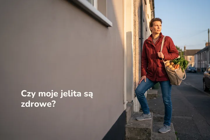 Czy moje jelita są zdrowe? — kobieta wchodzi wieczorem po schodach do domu z siatką warzyw