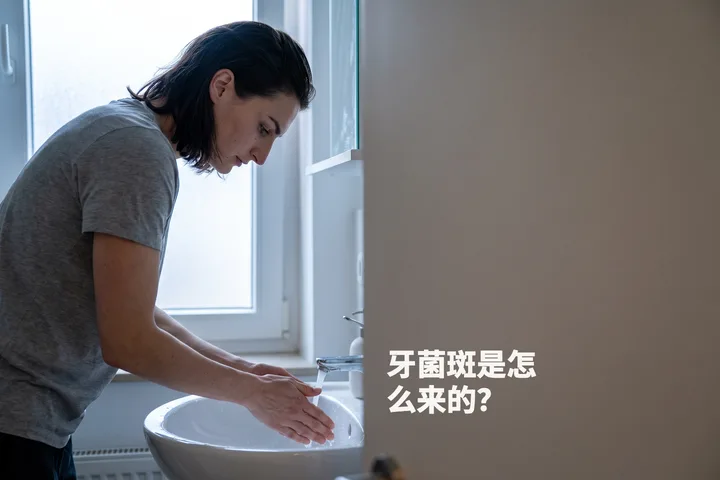 牙菌斑是怎么来的? — 清晨微凉的光线里,一位女性刚漱完口,俯身在洗手池上