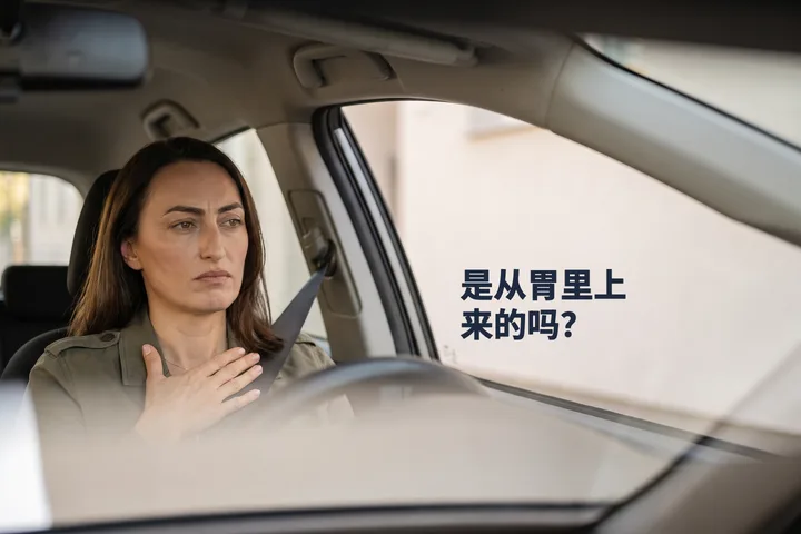 是从胃里上来的吗? — 上午,一位女性坐在停好的车里,一只手掌平贴在胃部