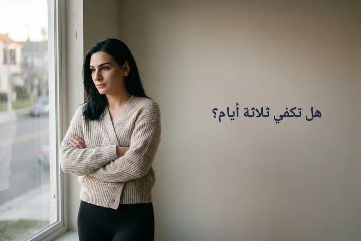 هل تكفي ثلاثة أيام؟ — امرأة عند نافذة غرفة جلوسها في الضوء المتأخر وذراعاها متشابكتان