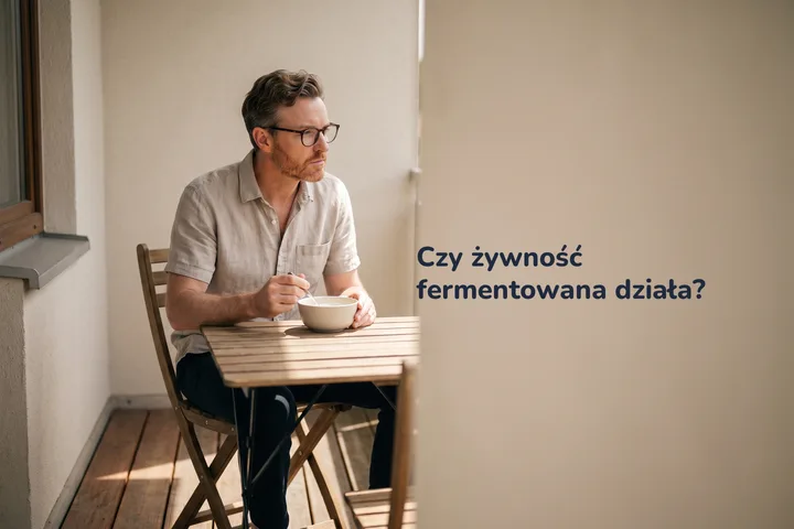 Czy żywność fermentowana działa? — mężczyzna je miskę kefiru przy stoliku na balkonie po południu